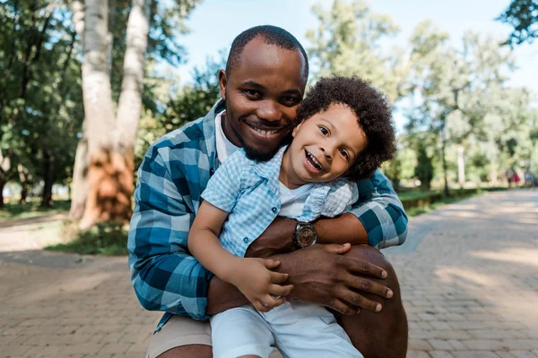 Cheerful African American Man Hugging Cute Curly Son — Stock Photo, Image