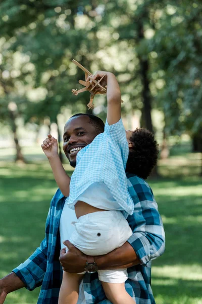Gülümseyen Afro Amerikan Adam Oyuncak Çift Kanatlı Ile Kollarında Sevimli — Stok fotoğraf