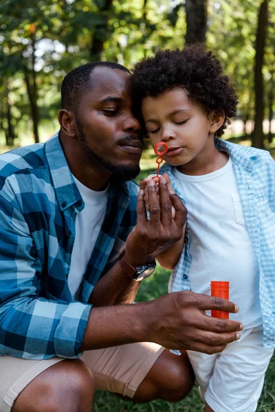 Vacker Afrikansk Amerikansk Far Och Lockig Son Blåser Tvål Bubbla — Stockfoto