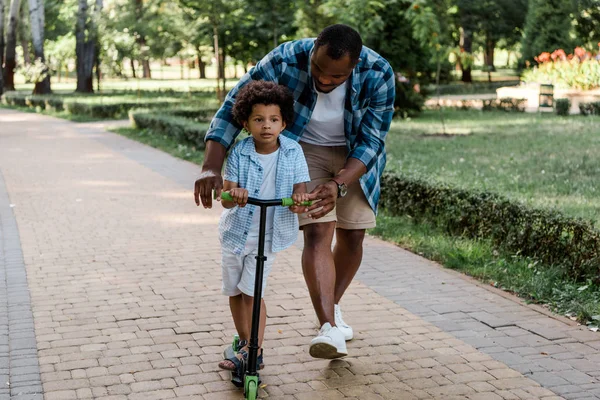 Barbudo Afro Americano Pai Olhando Para Encaracolado Filho Montando Scooter — Fotografia de Stock