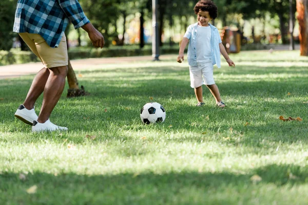 幸せな息子とサッカーをしているアフリカ系アメリカ人の父親のトリミングされたビュー — ストック写真