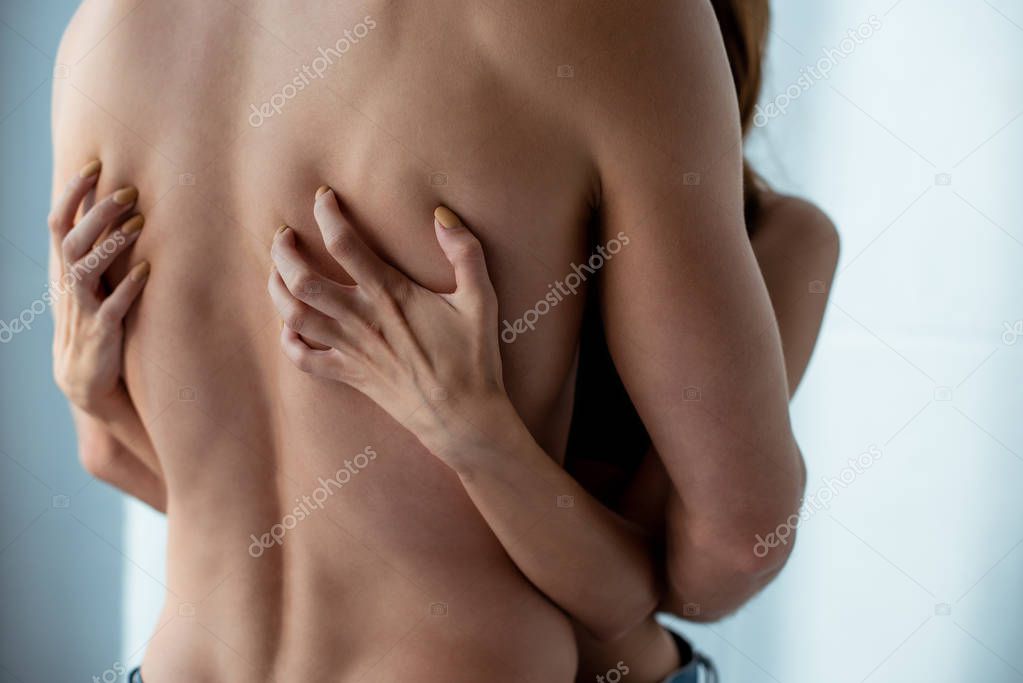 cropped view of seductive girl scratching back of boyfriend 