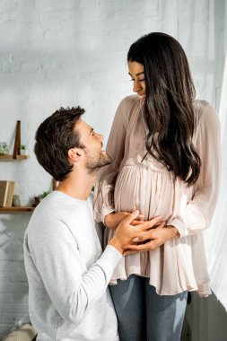 yakışıklı adam hamile afro-amerikan kadının karnına sarılma 
