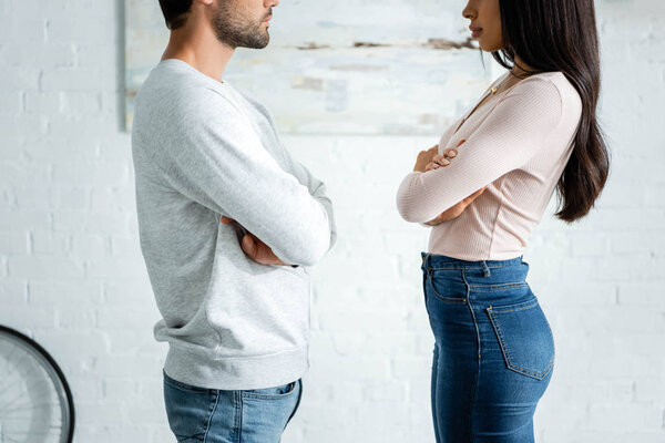 cropped view of upset african american woman and man with crossed arms 