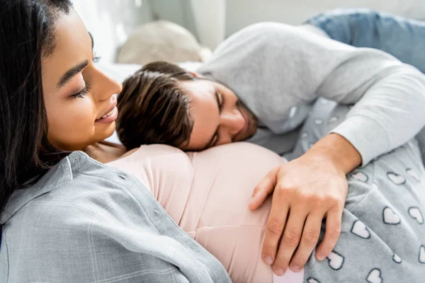 Foco Seletivo Homem Bonito Abraçando Ouvir Barriga Sua Mulher Americana — Fotografia de Stock