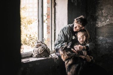 man hugging kid near german shepherd dog in abandoned building, post apocalyptic concept clipart