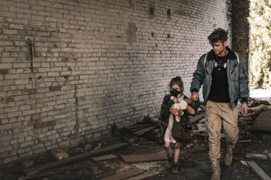 Çernobil 'de sokakta yürürken çocuğun elini tutan adam, kıyamet sonrası konsepti.