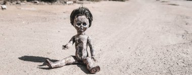 panoramic shot of old and scary baby doll on ground, post apocalyptic concept clipart