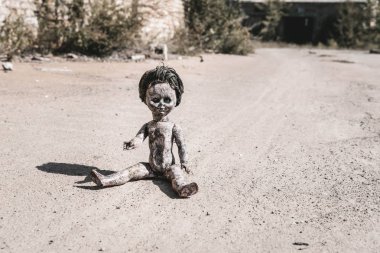 shadow near old and scary baby doll on ground, post apocalyptic concept clipart