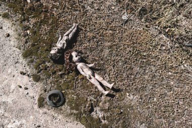 top view of scary and burnt baby dolls on ground, post apocalyptic concept clipart