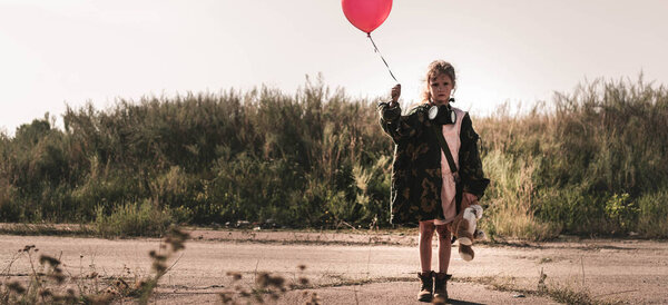 панорамный снимок милого ребенка в противогазе с воздушным шаром, постапокалиптическая концепция
