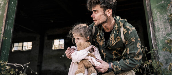 панорамный снимок испуганного мужчины и ребенка с плюшевым мишкой на улице, постапокалиптическая концепция
