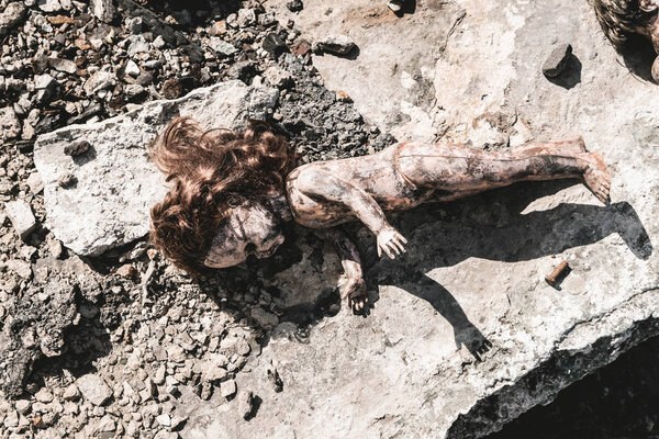 top view of dirty baby doll on ground, post apocalyptic concept