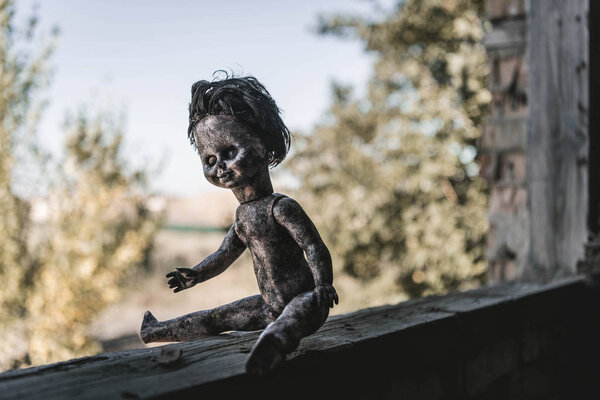 selective focus of scary and burnt baby doll, post apocalyptic concept