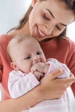 Neşeli bir anne kucağında sevimli bir kız bebek. 