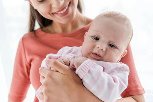 Vista Cortada Mãe Sorridente Segurando Braços Adorável Filha Bebê Casa — Fotografia de Stock