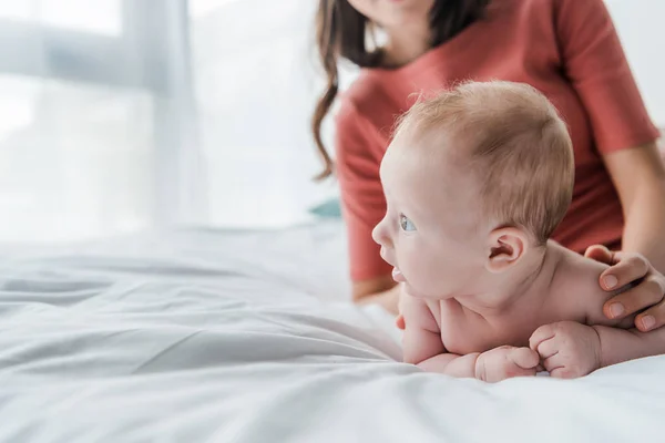 自宅で赤ちゃんの娘に触れる女性のクロップビュー — ストック写真