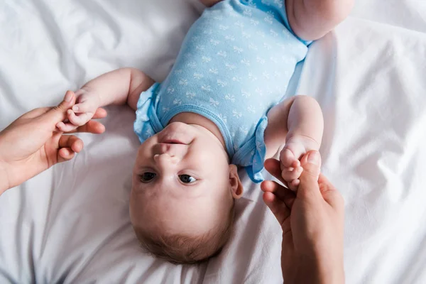 Top View Woman Holding Hands Infant Blue Bodysuit — Stockfoto