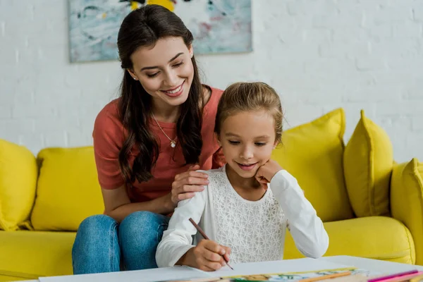 Babysitter Felice Seduta Sul Divano Giallo Vicino Disegno Bambino Soggiorno — Foto Stock