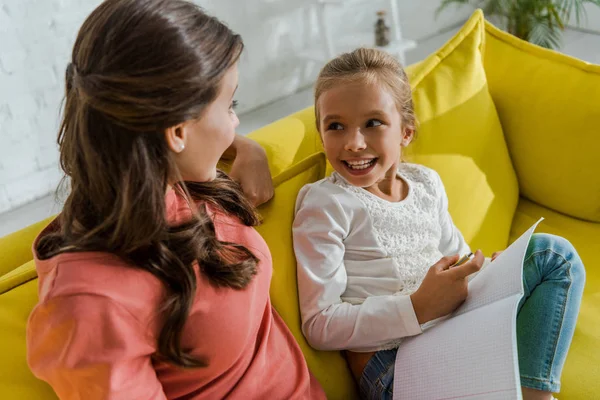 Glückliches Kind Hält Notizbuch Der Hand Und Schaut Babysitter Wohnzimmer — Stockfoto