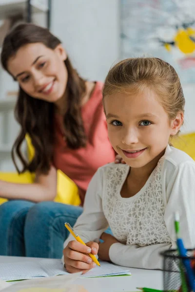 Selectieve Focus Van Gelukkig Kind Studeren Buurt Babysitter Thuis — Stockfoto