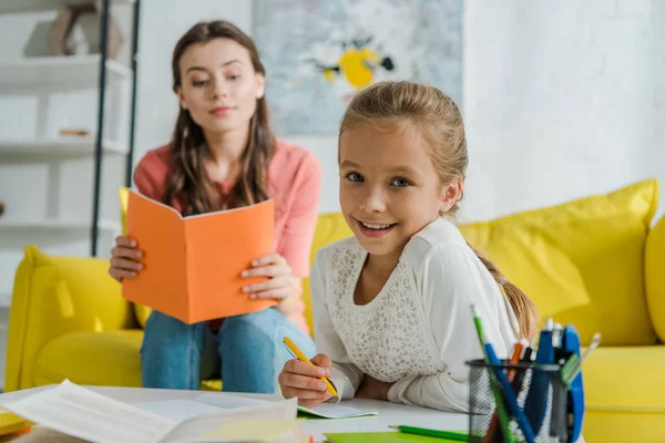 Foco Seletivo Criança Feliz Estudando Perto Livro Leitura Babá Casa — Fotografia de Stock