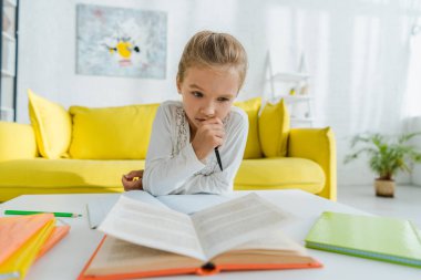 Düşünceli çocuğun evde ders çalışmasının seçici odağı 