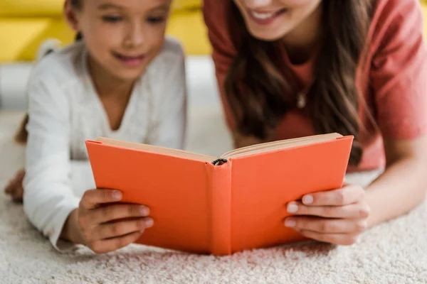 Kitap Okurken Tatlı Bir Çocukla Halının Üzerinde Uzanan Mutlu Bebek — Stok fotoğraf