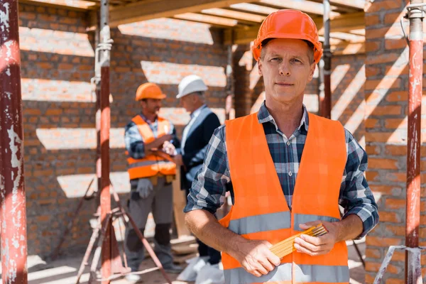 Selective Focus Mature Man Holding Equipment While Standing Coworker Businessman — 스톡 사진