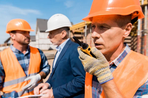 Selective Focus Builder Holding Walkie Talkie While Talking Coworker Businessman — 스톡 사진