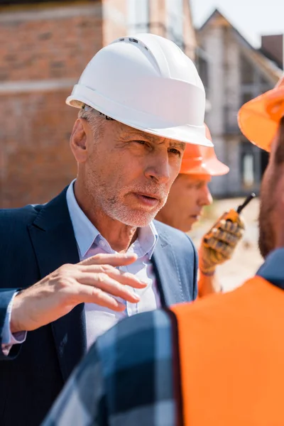 Selective Focus Mature Businessman Helmet Gesturing While Looking Constructor — Stock Photo, Image