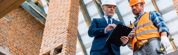 Plano Panorámico Hombre Negocios Barbudo Mirando Portapapeles Cerca Constructor —  Fotos de Stock