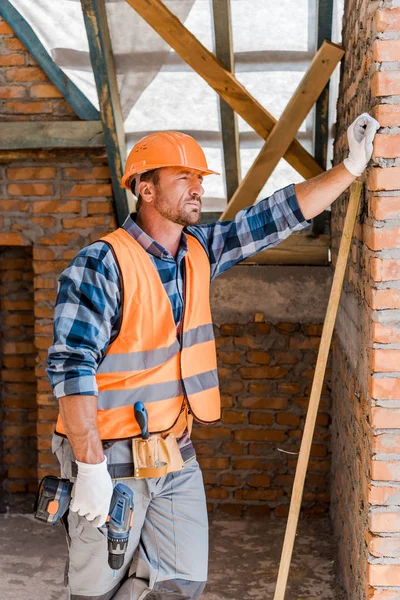 Handsome Constructor Helmet Holding Hammer Drill While Standing Brick Wall — Stock Photo, Image