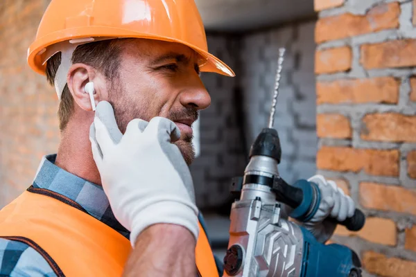 Handsome Man Holding Hammer Drill Touching Earphones — Stock Photo, Image