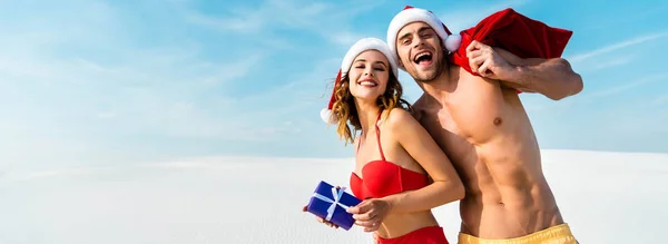 Panoramic Shot Sexy Smiling Girlfriend Holding Gift Boyfriend Santa Sack — Stock Photo, Image