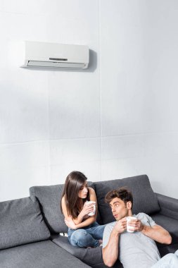 Çekici kız arkadaş ve elinde çay bardaklarıyla yakışıklı erkek arkadaş. 