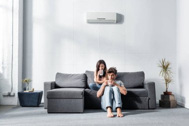 Çekici kız arkadaş ve elinde çay bardaklarıyla yakışıklı erkek arkadaş. 