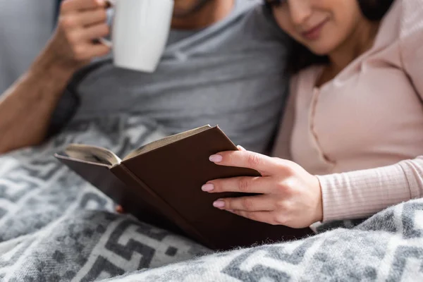 Cropped View Girlfriend Reading Book Boyfriend Holding Cup Tea — Stock Photo, Image