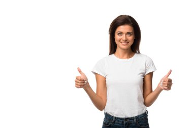 Beyaz tişörtlü mutlu kadın beyaz tişörtle izole edilmiş, baş parmağını gösteriyor.
