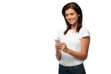 Akıllı telefon kullanan gülümseyen genç bir kadın, beyaz üzerinde izole edilmiş.