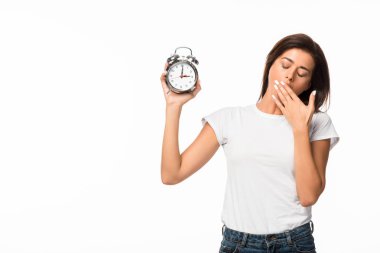 tired woman yawning and holding alarm clock, isolated on white clipart