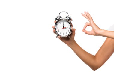 partial view of woman holding alarm clock, isolated on white clipart