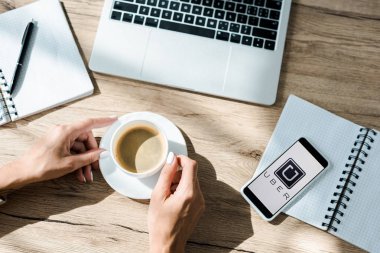 Kyiv, Ukrayna - 10 Eylül 2019: Uber uygulamalı bir fincan kahve, dizüstü bilgisayar ve akıllı telefon ile serbest görüşü 