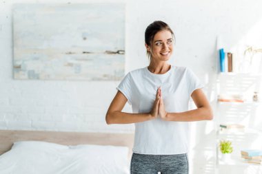 Güzel gülümseyen kız sabah namaste tabelasıyla yoga yapıyor. 