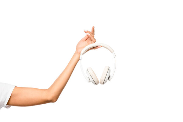 cropped view of young woman holding headphones, isolated on white