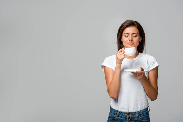beautiful woman with closed eyes holding cup of coffee, isolated on grey