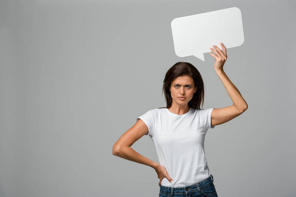 beautiful angry woman holding empty speech bubble, isolated on grey