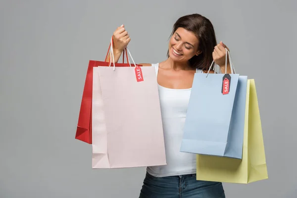 Mujer Feliz Sosteniendo Bolsas Compras Con Letreros Venta Aislado Gris — Foto de Stock