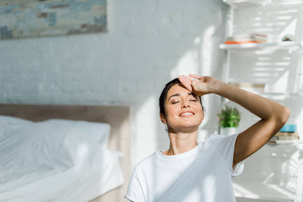beautiful cheerful girl with closed eyes doing morning exercise in bedroom