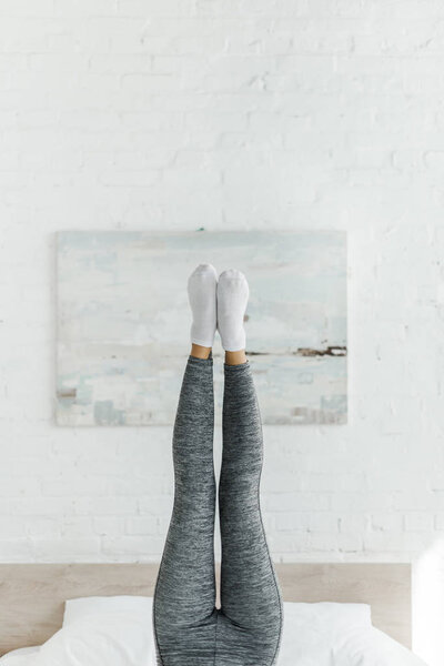 cropped view of girl doing morning exercise in bedroom